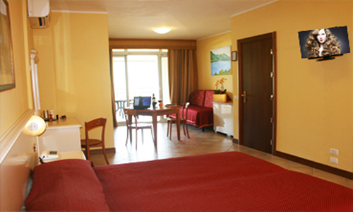 Superior Room,  recently renovated,  modern furniture. All have a bathroom with box shower and offer every comfort for a pleasant stay. The rooms have a living room and a balcony with lake views. Room size: 25/35 sqm, One Bedroom with double bed and a Living area with one sofa bed, Bathroom with shower box, Covered terrace,  with table, Sheets and towels, Satellite TV, Air conditioning, Refrigerator, Private safe & Telephone, Buffet Breakfast